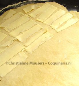 One half of the rolled-out dough is covered with thinly sliced butter