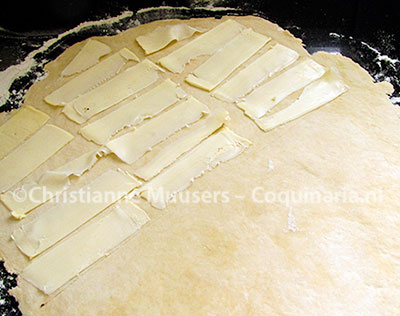 Slices of butter are placed on the sheet of dough