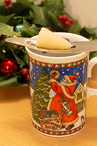 Individual cup of Feuerzangenbowle: mini sugar-tongs, min sugar cone, and a Christmas mug