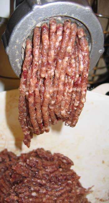 Het vlees voor de farce wordt gemalen. De witte stukjes zijn vet spek en witbrood, de donkerrode varkenslever.